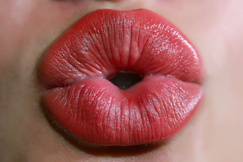 用时尚红色唇膏贴近年轻女子的嘴唇