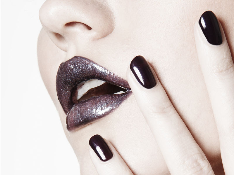 女人们把美丽的紫色嘴唇和指甲放在白色的背景上