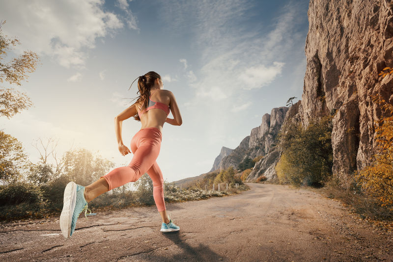 年轻女子在山路上奔跑-在美丽的大自然中-穿着运动鞋的女跑步者在户外慢跑锻炼-减肥概念-健康的生活方式-户外健身