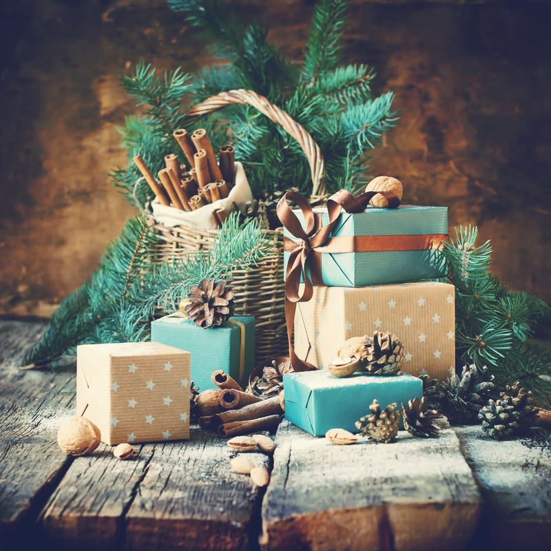 圣诞卡礼品盒篮子松果核桃木背景色调的