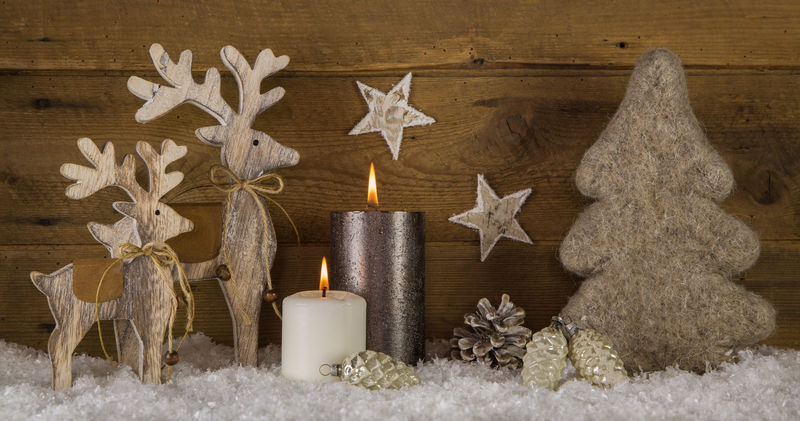 天然木白色棕色圣诞装饰与两支燃烧的蜡烛