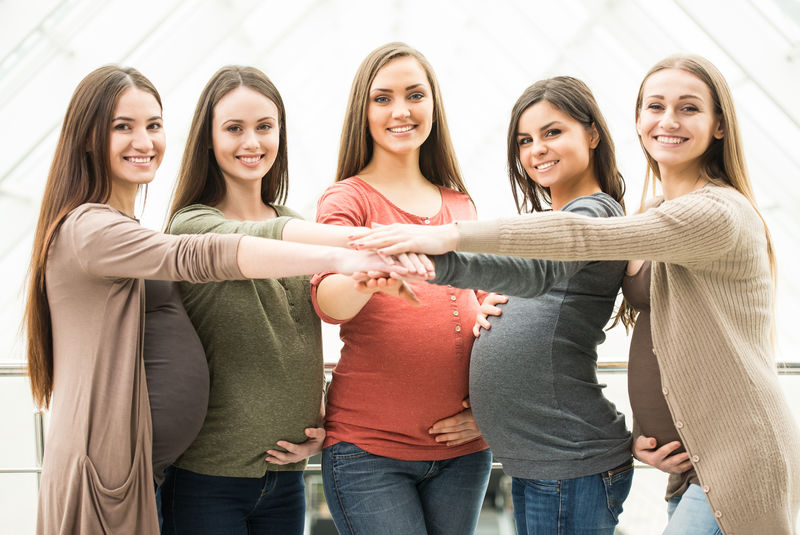 五位快乐友好的孕妇正看着摄像机