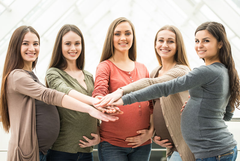 五位快乐友好的孕妇正看着摄像机