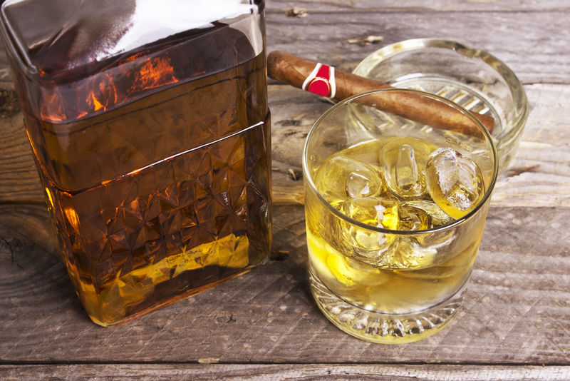 一瓶威士忌和一杯古巴雪茄