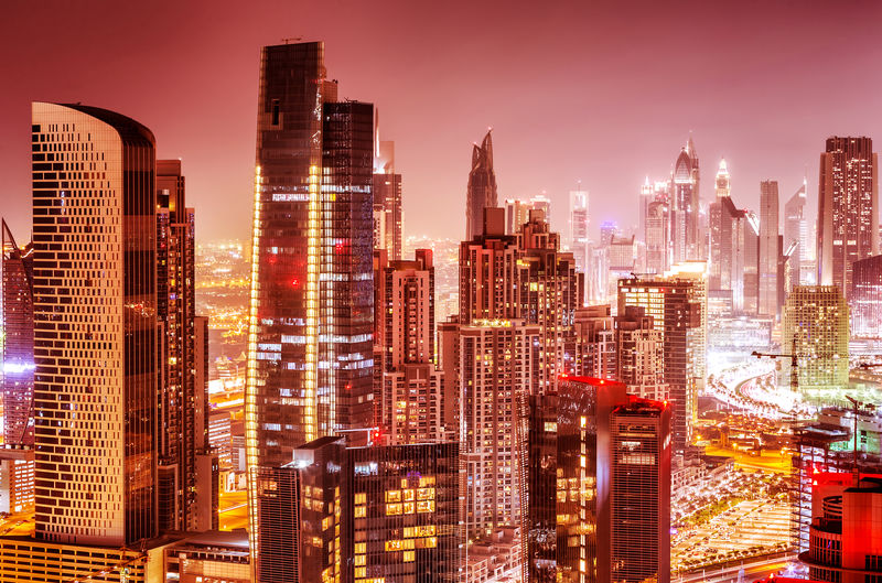 夜晚迪拜的美丽背景粉红天空中绚丽的城市景色高楼大厦的许多耀眼灯光奢华的现代昂贵的建筑设计