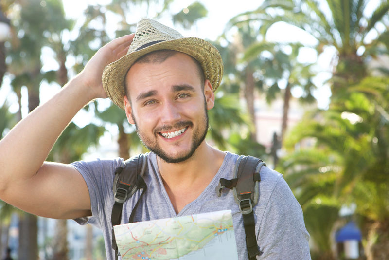 一个拿着包和帽子的快乐男人度假的画像