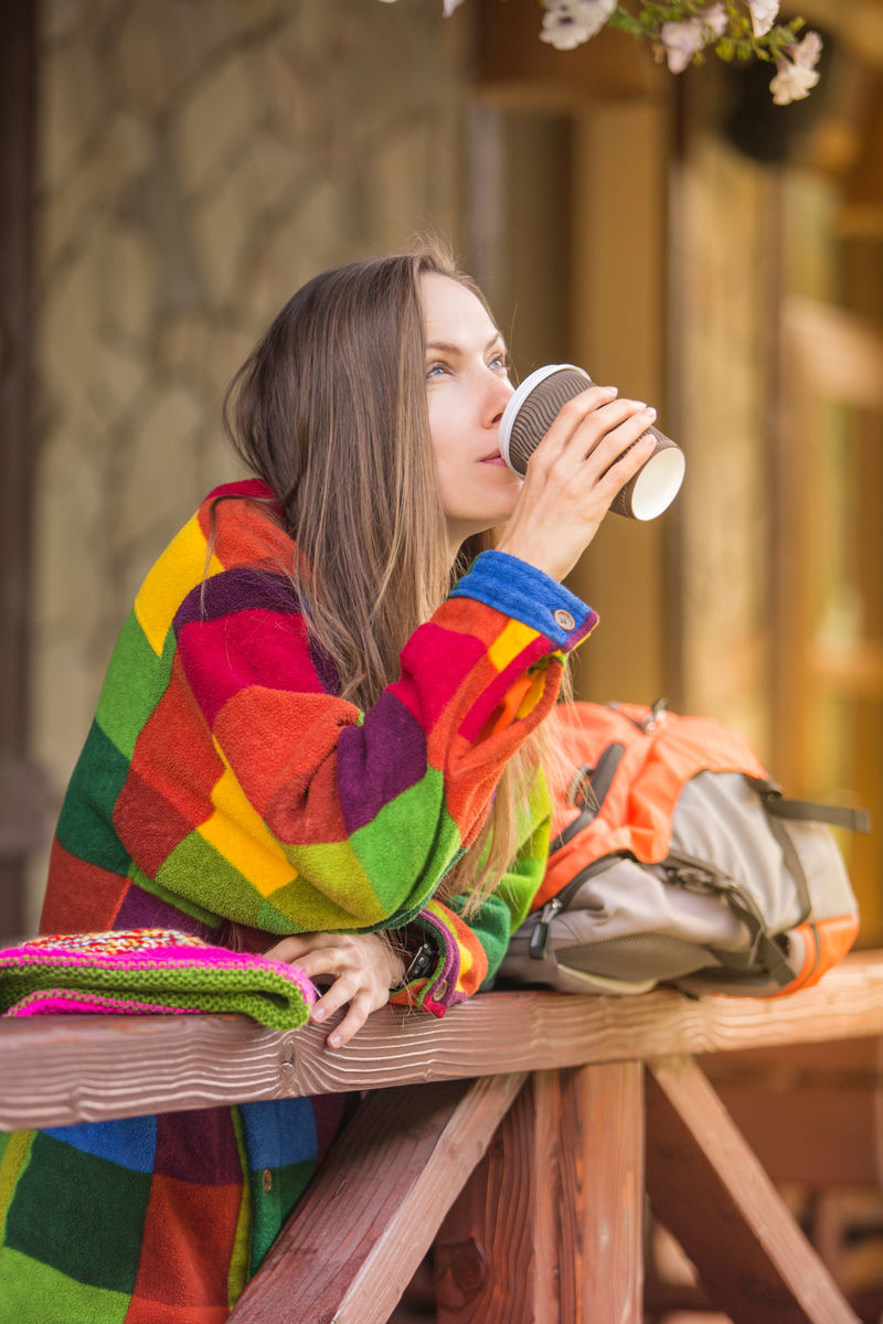 秋天的旅行者女人喜欢徒步旅行在路边的咖啡馆里放松地喝着热茶