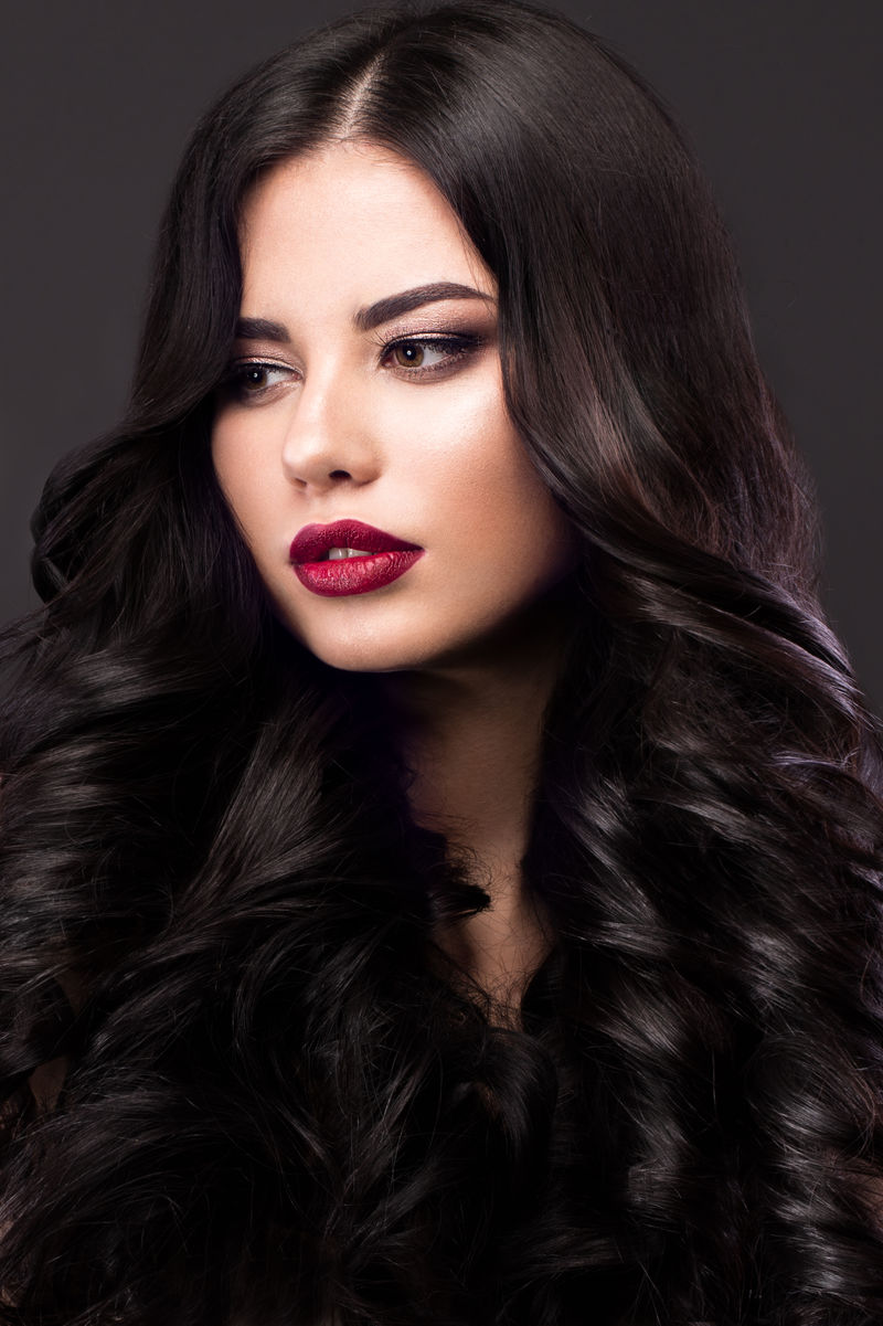 美丽的黑色卷发经典模型：化妆和红色的嘴唇美丽的脸庞