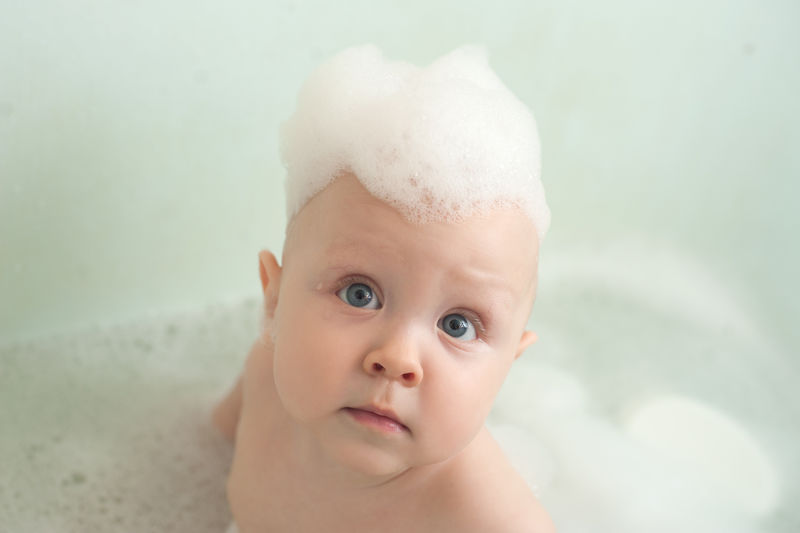 浴室里的孩子用洗发水泡沫洗头