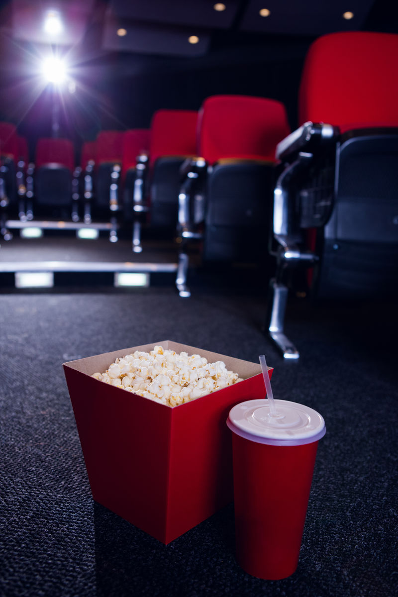 电影院里一排空座位上放着爆米花和饮料