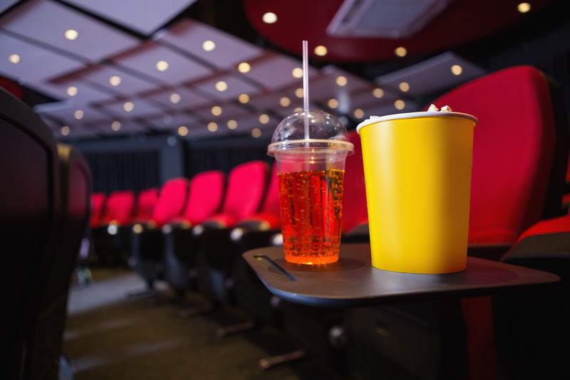 电影院里一排空座位上放着爆米花和饮料