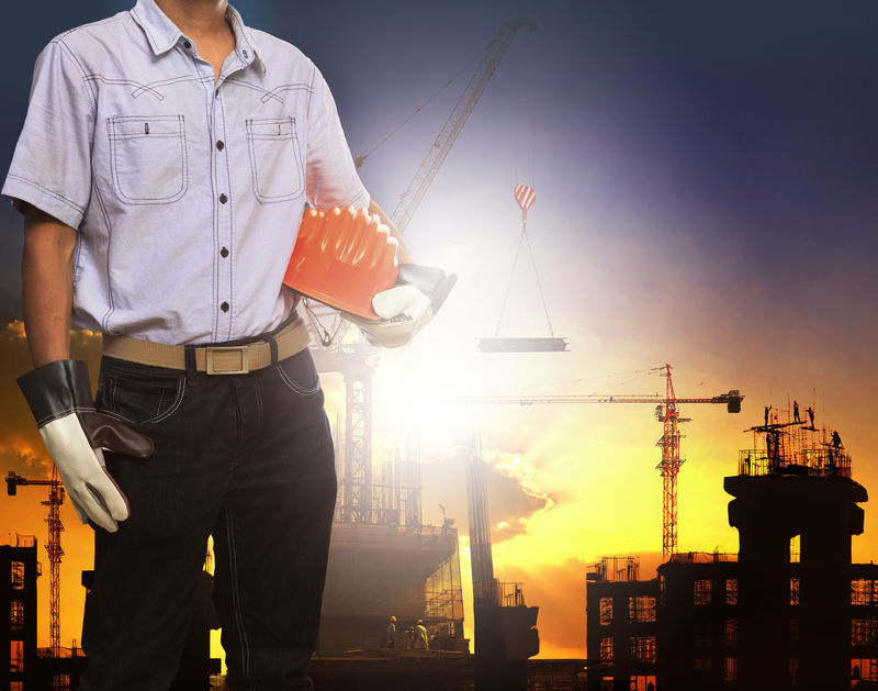 工程师戴着白色安全帽在起重机和建筑工地上工作用于土木工程和施工