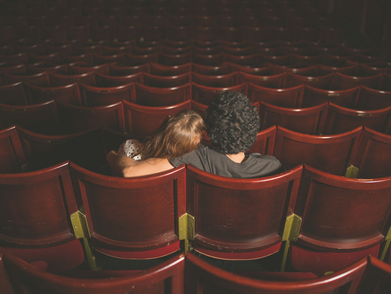 坐在电影院的年轻夫妇