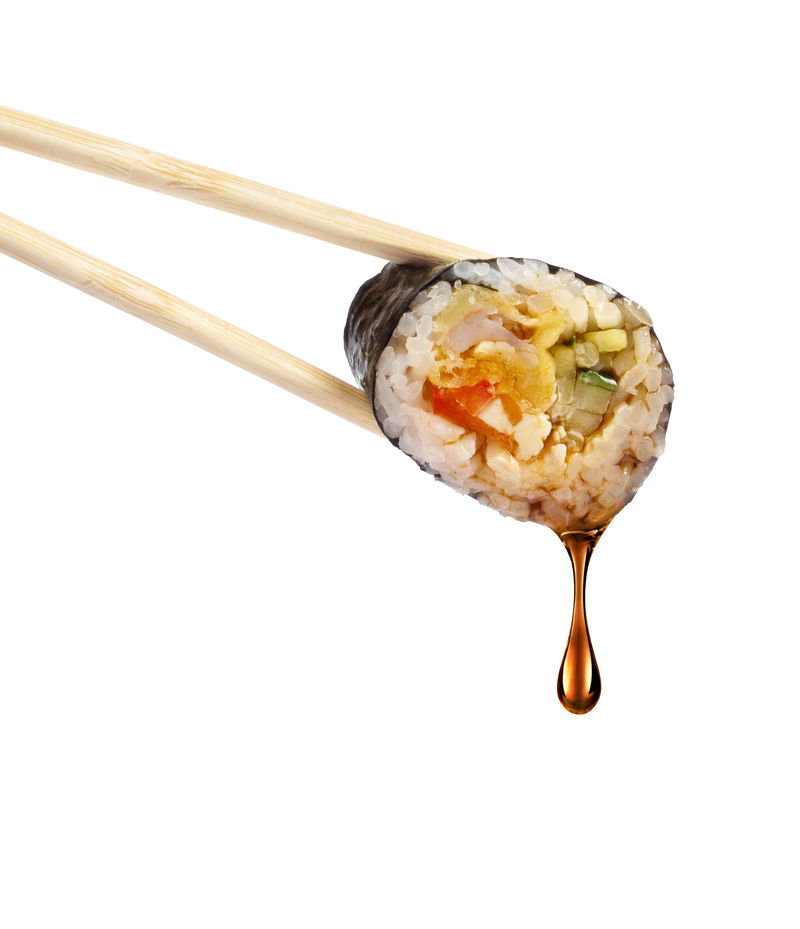 一滴酱油从寿司卷上滴下白色背景隔离