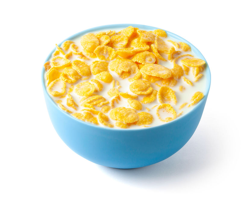 玉米片加牛奶的干早餐蓝色盘子里装满了谷物和牛奶白底隔离