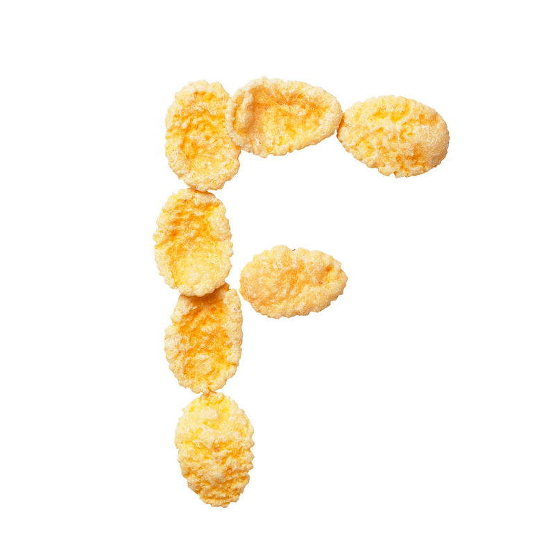 白色背景上的黄色玉米片字母F字母谷物薄片