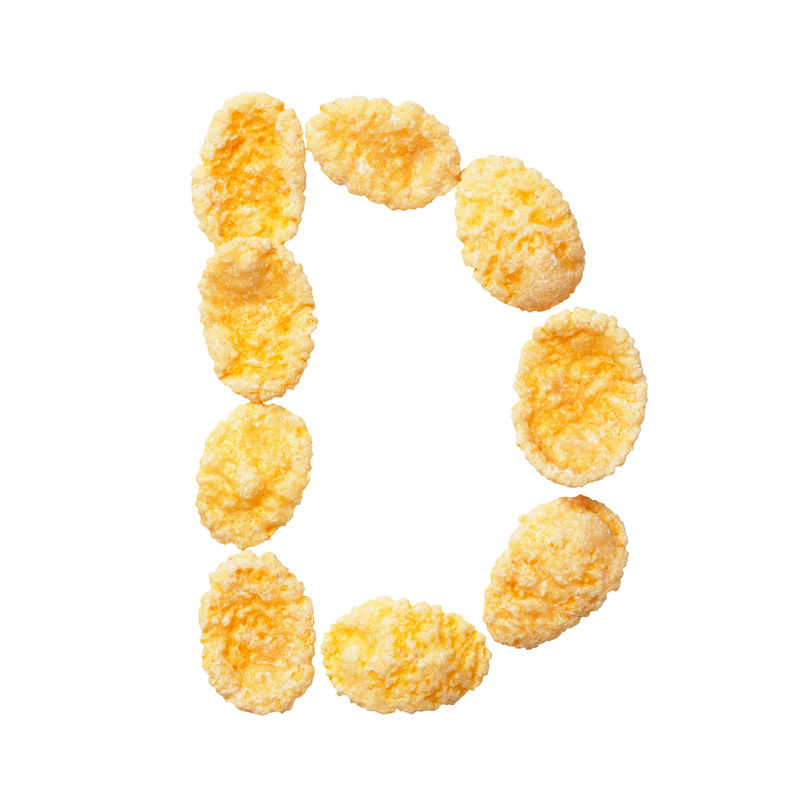 白色背景上的黄色玉米片字母D字母谷物薄片