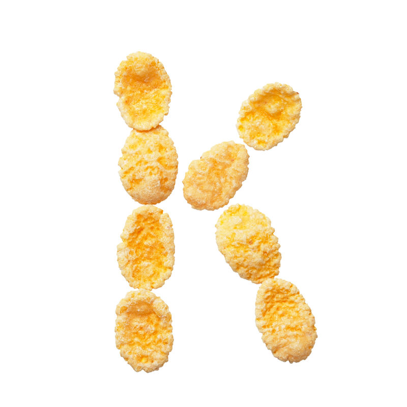 白色背景上的黄色玉米片字母K字母谷物薄片