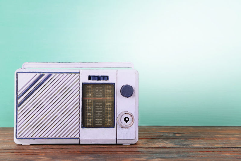 蓝色背景木桌上的旧收音机