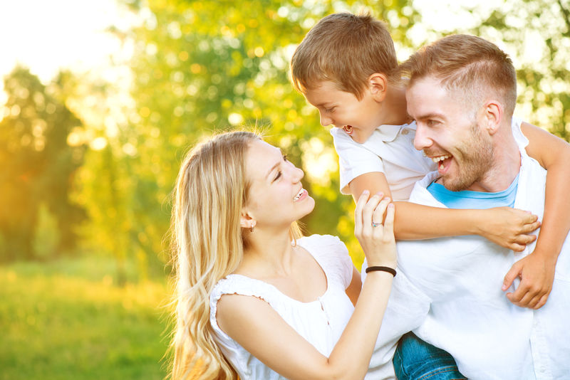 快乐快乐的年轻家庭在夏季公园享受户外乐趣