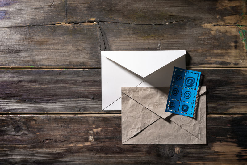 信封和邮戳在旧木面上贴上电子邮件标志
