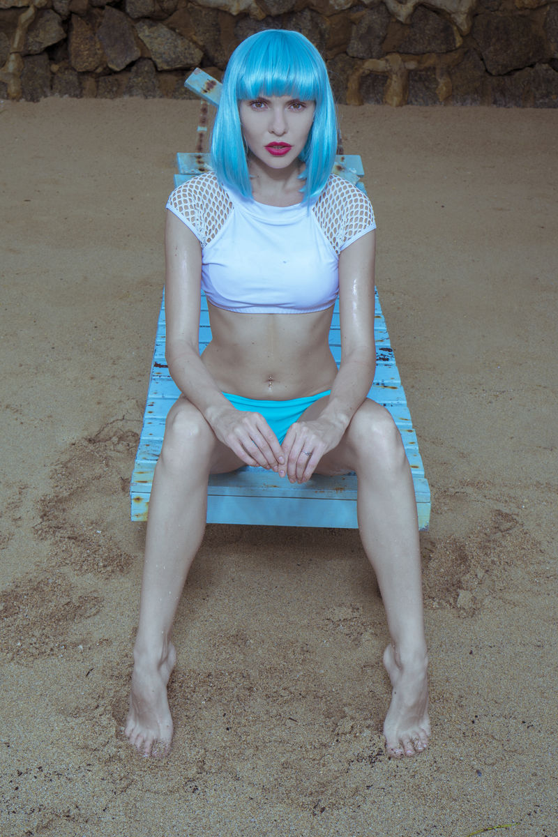 性感美女以现代未来风格摆在受损木蓝色太阳床上海滩美女穿比基尼和蓝假发的创意