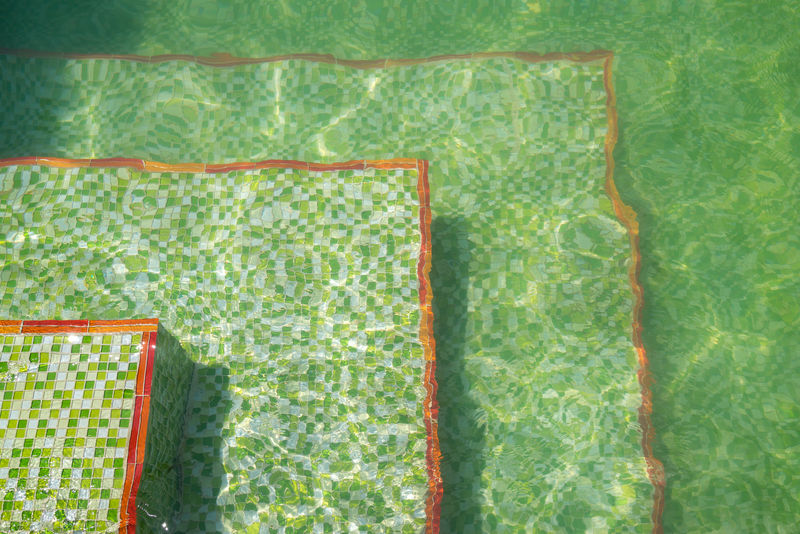 游泳池地面有波纹和绿色马赛克瓷砖