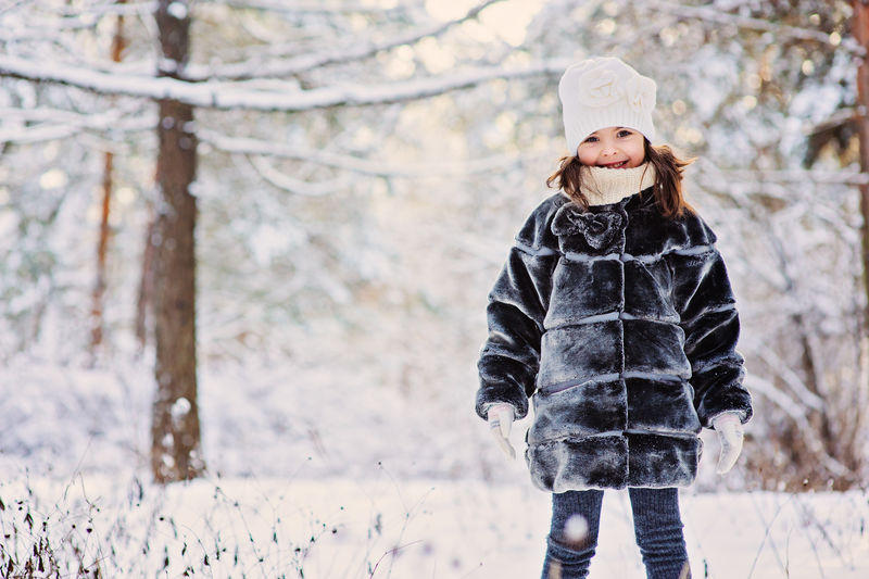 穿着灰色皮衣的可爱快乐女童的冬季肖像