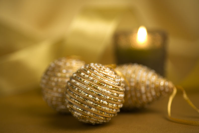 金色背景的玻璃珠圣诞饰品和蜡烛