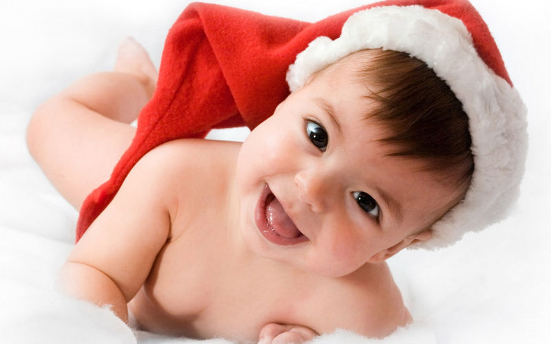 可爱的婴儿微笑着戴着白色背景的圣诞帽