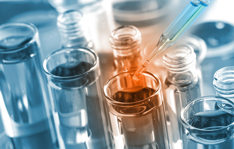 化学家将澄清试剂滴入试管-在化学实验室进行反应测试