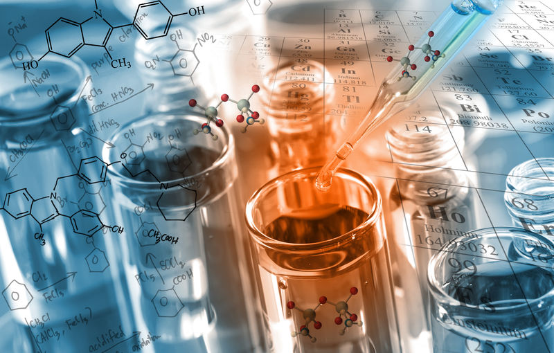 化学家将澄清试剂滴入试管中-在化学实验室中进行反应测试-并以化学方程式和周期表为背景