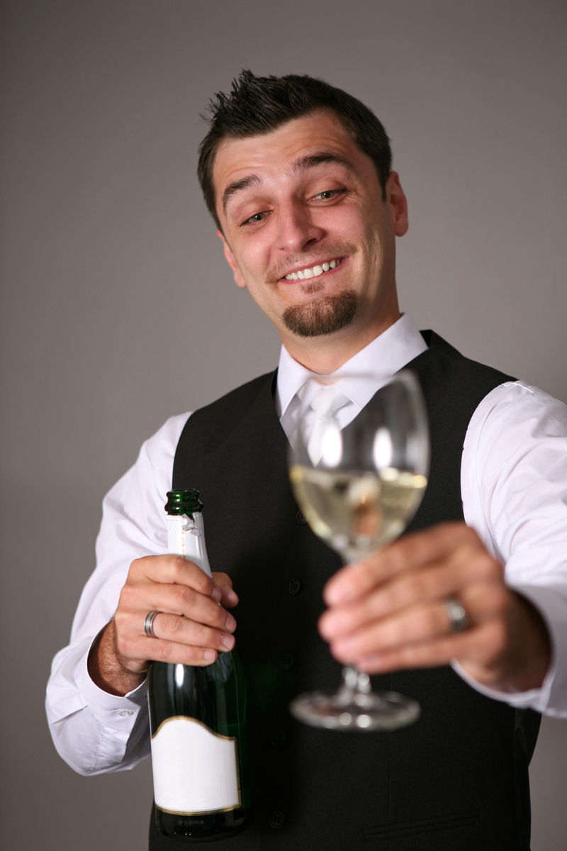 一个穿着燕尾服带着香槟酒瓶的英俊男人