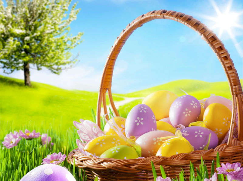 春季草坪上的复活节彩蛋艺术篮子