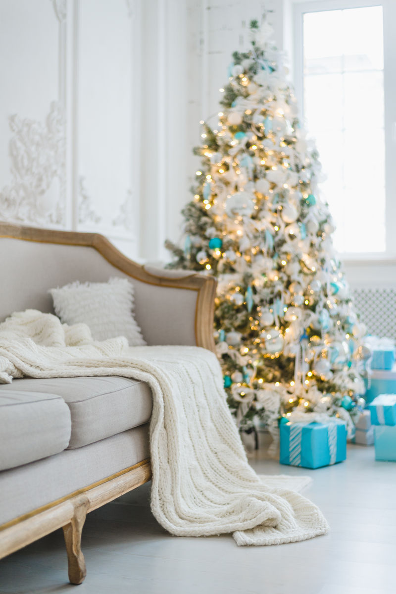 宁静的形象豪华的室内客厅装饰圣诞树和礼物沙发上盖有毯子选择性聚焦