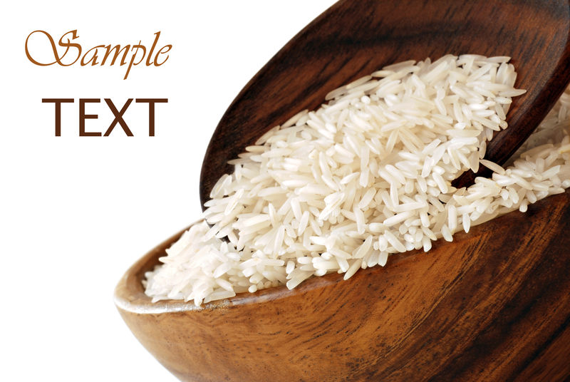 未煮熟的米饭放在木盆里-汤匙放在白色背景上-留有复印空间-具有浅度的宏