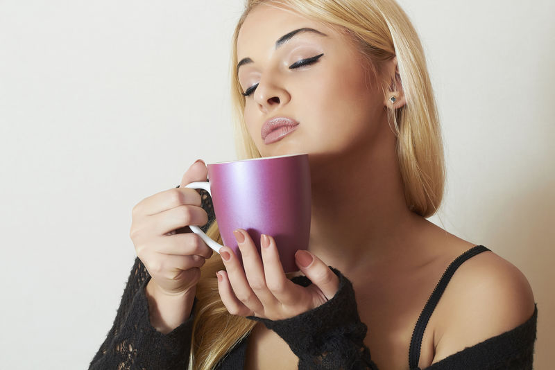 美丽的金发女人喝咖啡-一杯茶-热饮料好吃