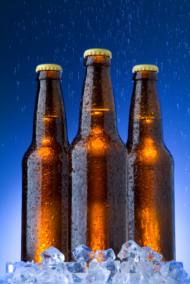 冰镇啤酒和蓝色背景下的雨水