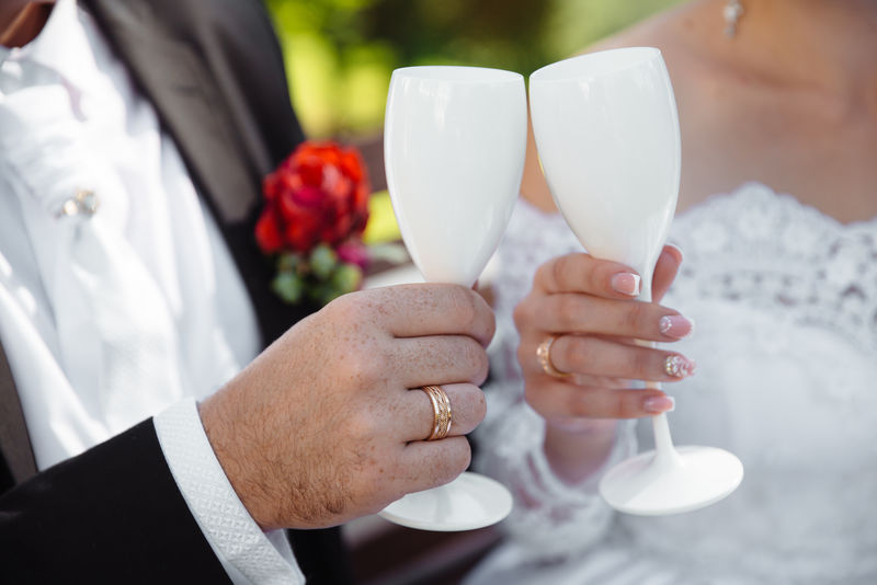 新娘和新郎手上戴着白色玻璃戒指