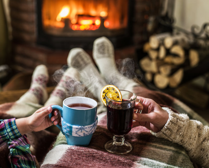 用一杯热饮在壁炉附近取暖放松