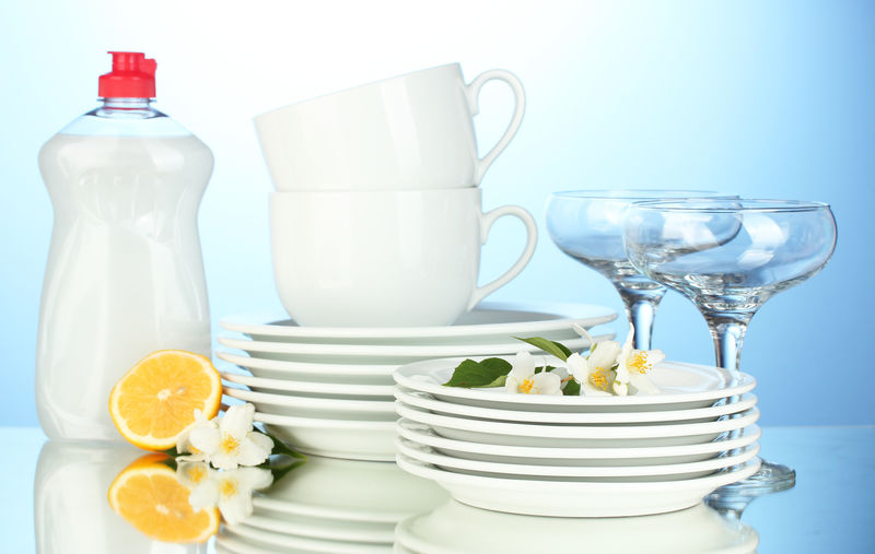 清空干净的盘子玻璃杯和杯子-用洗碗液和蓝底柠檬清洗