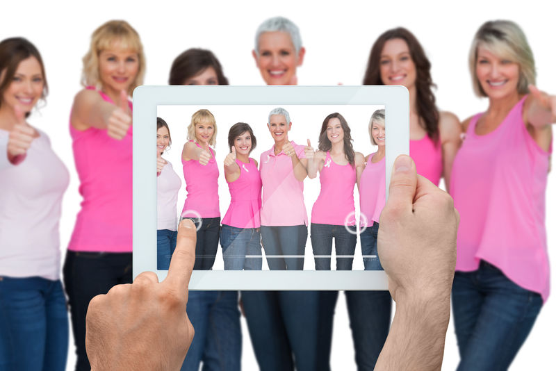 手持平板电脑的合成图像显示乳腺癌活动家的照片