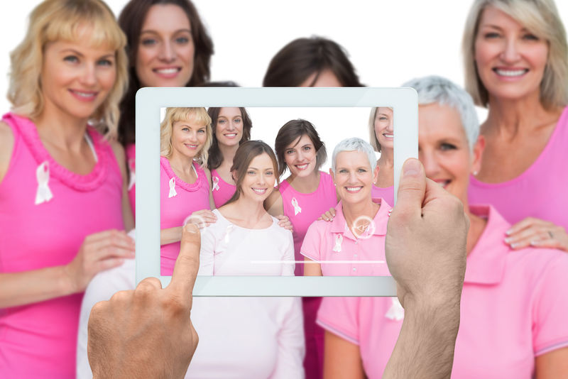 手持平板电脑的合成图像显示乳腺癌活动家的照片
