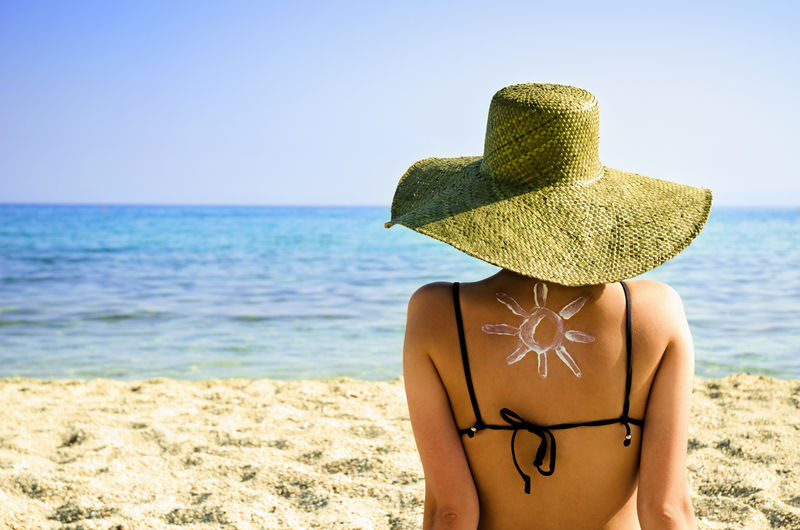 海滩上背着太阳符号的女人