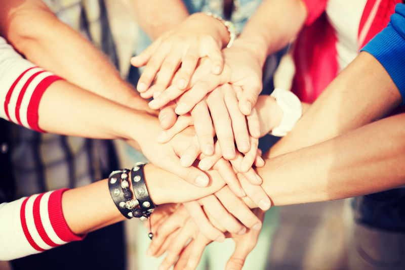 团队合作的理念：手的特写：业务团队表现出团结一致的双手放在一起