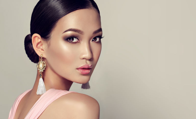 亚洲时装模特-戴着流苏耳环和粉色连衣裙