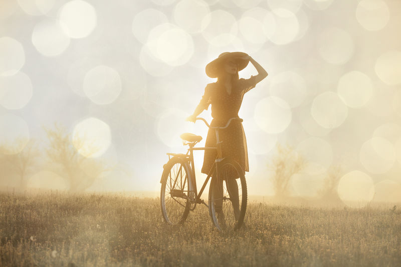 日出时在乡下骑自行车的女孩