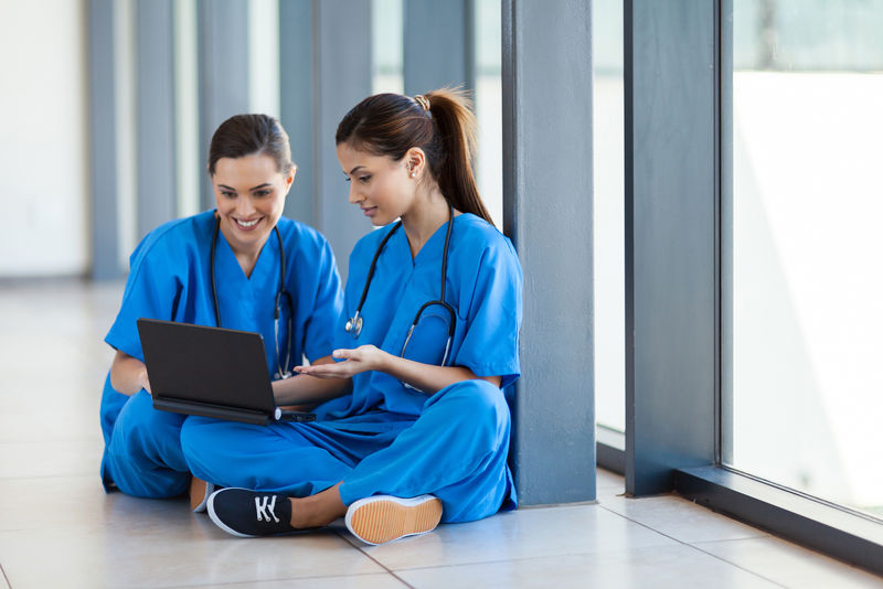 两名护士在休息时使用笔记本电脑