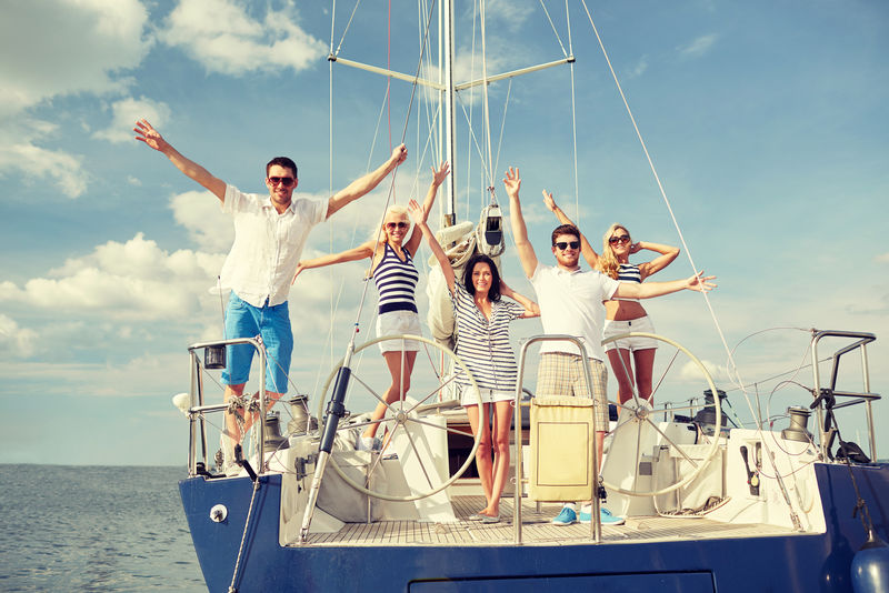 度假旅行海上友谊和人民观念微笑的朋友坐在游艇甲板上迎接