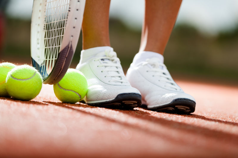 运动员靠近网球拍和球的腿